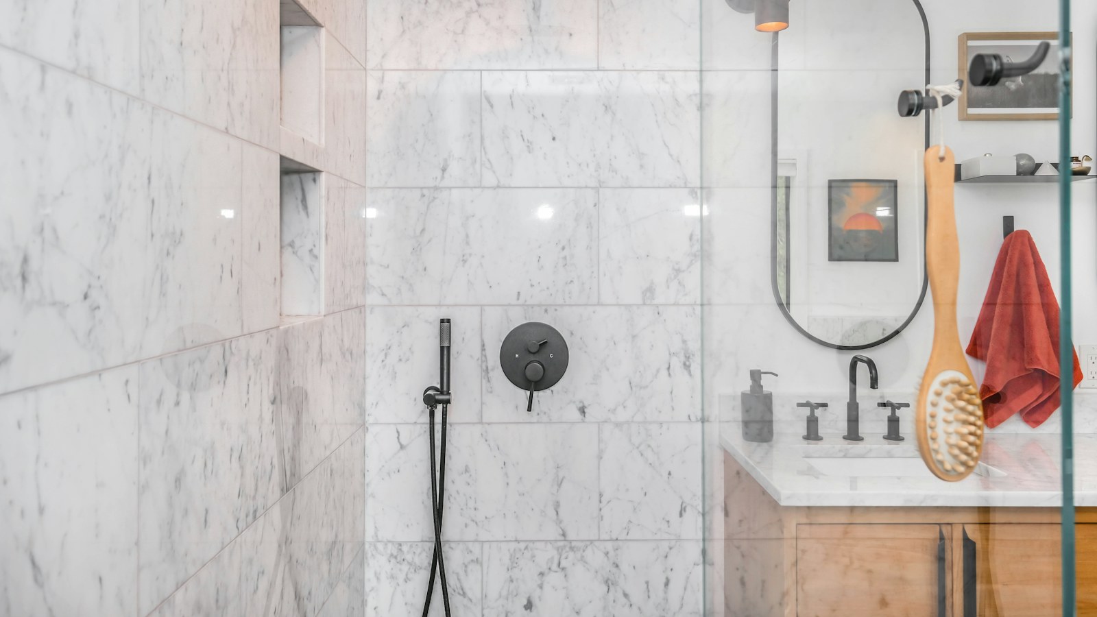 Douche avec paroi vitrée et robinetterie chromée dans une salle de bain claire
