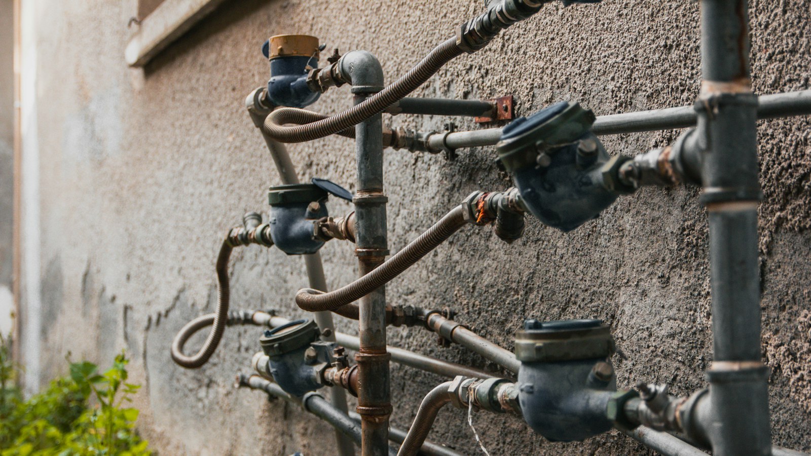 Plusieurs compteurs d’eau raccordés sur un mur