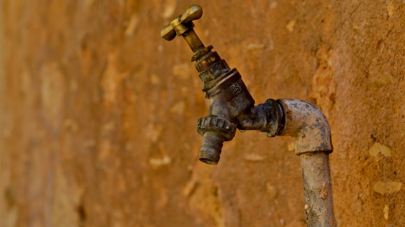 Ancien robinet en métal rouillé sur un mur