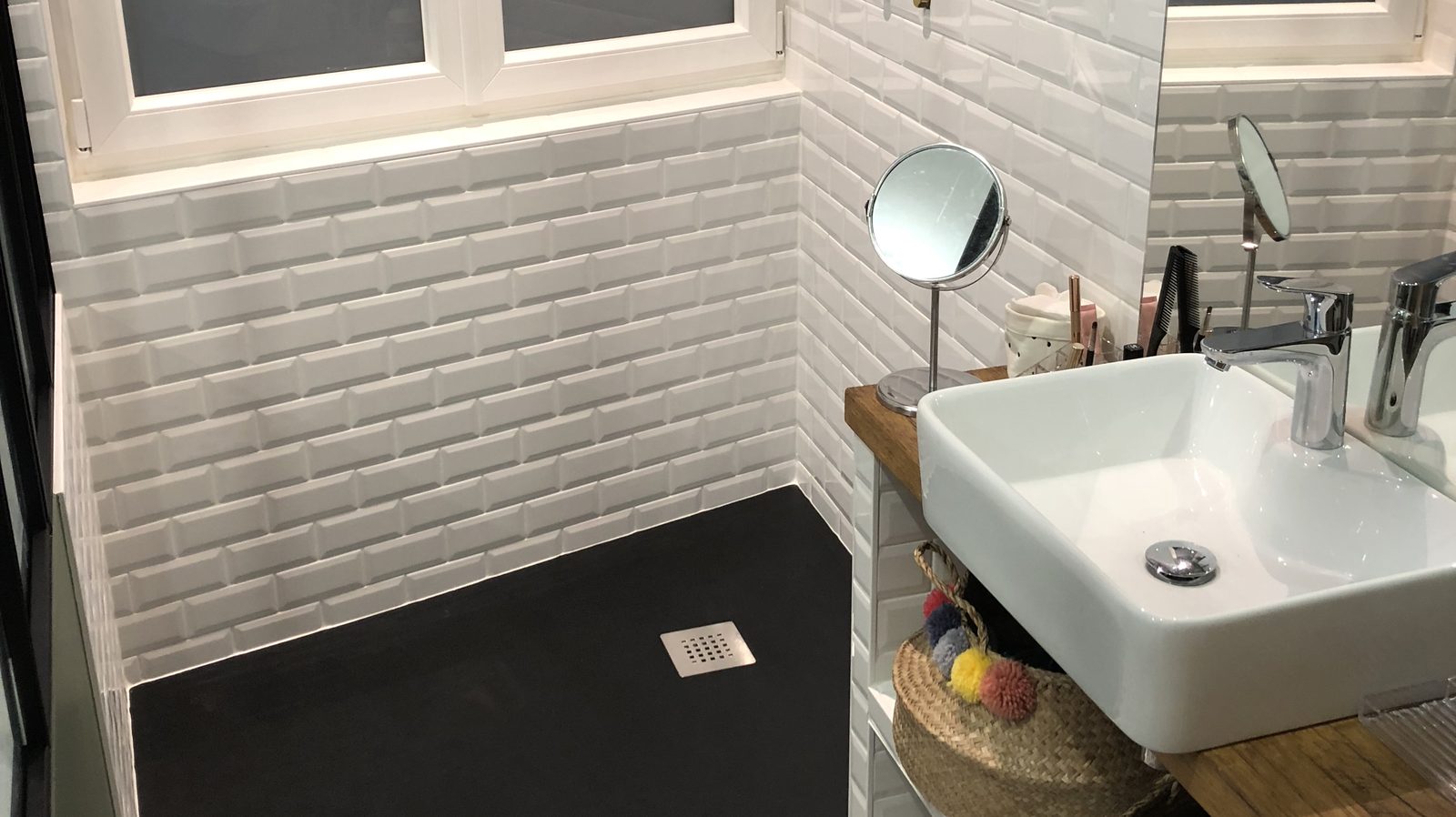 Salle d'eau créée dans une chambre : receveur noir découpé dans l'angle et faïence blanche métro