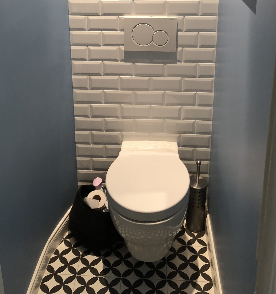 WC suspendu Geberit avec habillage du bâti en faïence blanche métro et carrelage au sol noir et blanc